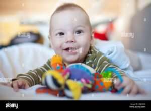 bebe sonriente con juguetes suaves coloridos
