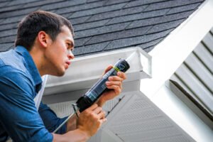 mano aplicando sellador de silicona en techo