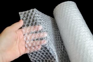 Por qué Usar Plástico con Burbujas Para Embalaje Es Tan Efectivo 14 mano sosteniendo plastico de burbujas transparente