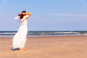 mujer con vestido blanco largo en playa