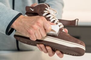 tenis de gamuza siendo limpiados suavemente